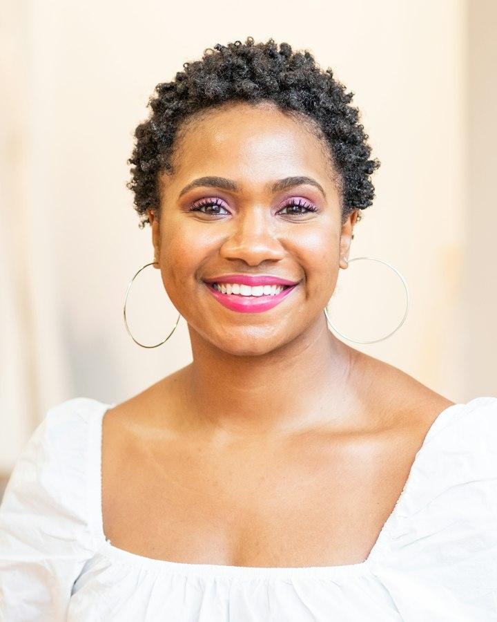 A woman with hoop earrings, smiling