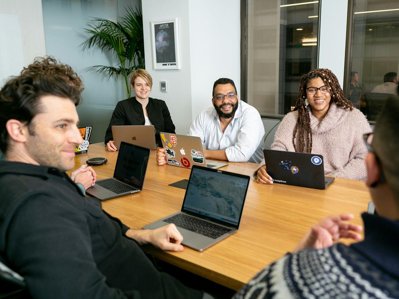 A team working together around a table with laptops